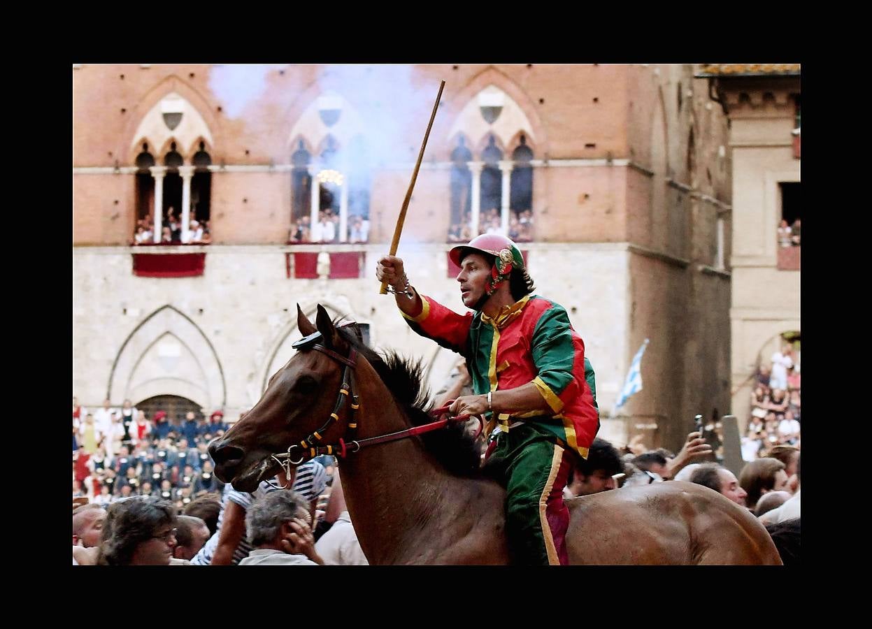 En la Piazza del Campo, en pleno corazón de Siena, en la Toscana, se celebra cada año, en dos ocasiones (las fotografías se tomaron el 2 de julio), la carrera de caballos de origen medieval conocida como «Il Palio.» La ciudad se engalana con estandartes, blasones y guirnaldas para celebrar tres días de alegría durante los cuales, además de participar en las bendiciones de los animales, es posible disfrutar de música y conciertos. En la carrera participan diez caballos, que representan a alguna de las «contradas» o distritos de la ciudad, y han de dar tres vueltas completas a la Piazza del Campo. El primero en terminarlas, con o sin jinete, será el ganador.