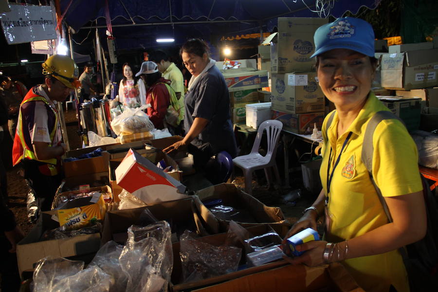 Con polos amarillos de la monarquía tailandesa, los voluntarios reparten comida y ropa entre el dispositivo de rescate. P.