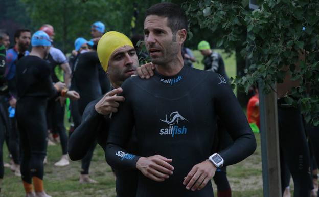 Los triatletas se ajustan los trajes de neopreno antes de lanzarse al agua.