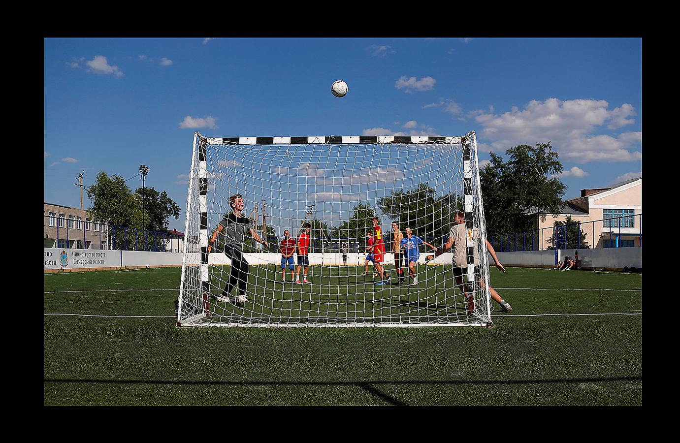 En Aleksandrovka, una aldea de 1.500 habitantes, el campo de fútbol está en el centro de muchas relaciones. Bajo la mirada firme de Lenin, el pequeño campo construido hace cinco años como regalo de la ciudad de Samara sirve a la comunidad para que los jóvenes imiten las habilidades de sus héroes del balón. Sin embargo, para algunos campesinos de la región, la Copa del Mundo es su primer encuentro con el fútbol. Irina Aleekseva, que vive sola en una vieja casa de madera (aparece desplumando una gallina), ha visto las noticias para conocer el juego y relacionarse con sus nietos, que la visitan para ayudarla con la granja. «Debería ser una abuela moderna y saber quiénes son Ronaldo y Messi».