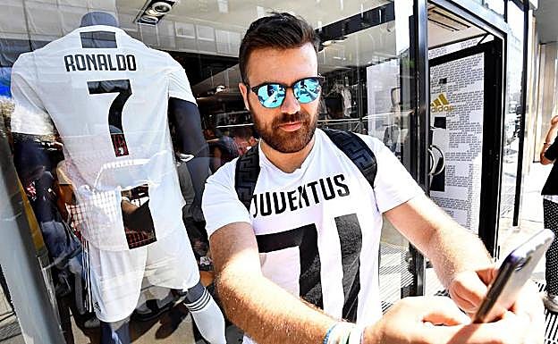 Un aficionado posa con la nueva camiseta de Cristiano Ronaldo de la Juventus.