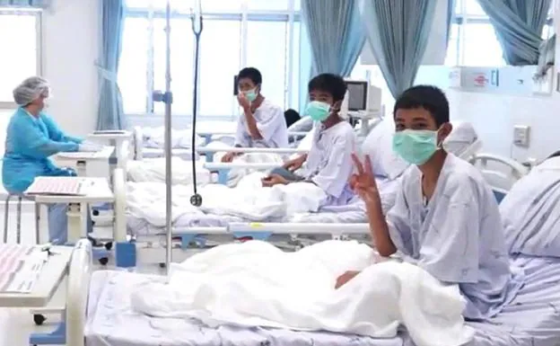 Tres de los menores tailandeses rescatados de la cueva de Tham Luang saludan desde la sala del hospital donde reciben atención médica.