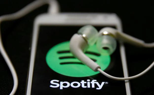 Auriculares sobre el logotipo de Spotify. 