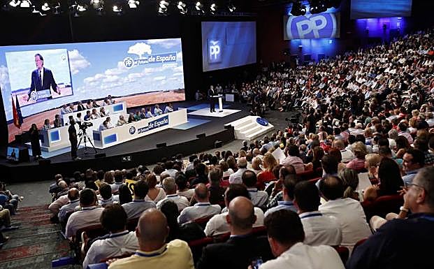 Varios asistentes al Congreso Nacional del Partido Popular atienden al discurso de Mariano Rajoy. 