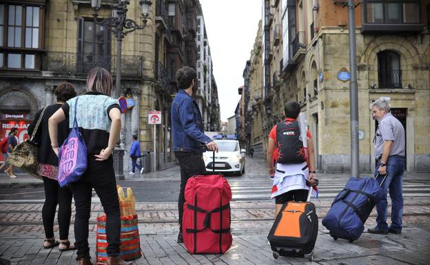 Turistas con maletas por Bilbao.