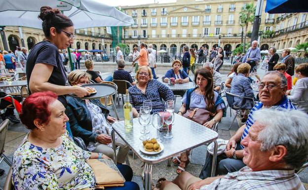 Pertsona batzuk, Bilboko Plaza Berriko terraza batean.