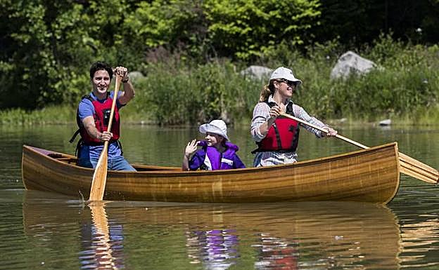 Justin Trudeau y su esposa, Sophie Grégoire, pasean a su hija, Ella Grace, en kayak por el lago de un parque natural. Arriba, tomando el sol.