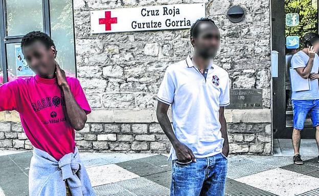 Dos inmigrantes junto a la sede de Cruz Roja en Vitoria.