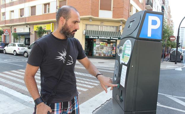 Un hombre paga la OTA en una céntrica calle de Vitoria.