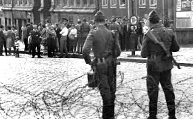 Soldados de la Alemania Oriental vigilan a ciudadanos berlineses durante la construcción del Muro.