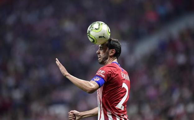 Diego Godín despeja un balón de cabeza en el Metropolitano. 