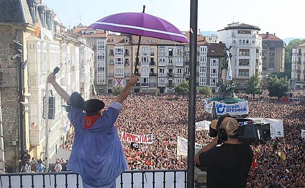 Celedón, con su paraguas morado desde la balconada.