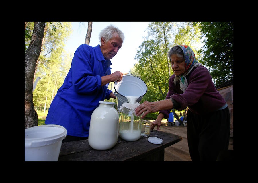 Yuri Baikov, de 69 años, hace un agujero para extraer agua del río congelado en su pequeña granja situada en un bosque cerca de la aldea de Yukhovichi, Bielorrusia, el 7 de febrero de 2018. Yuri y su esposa han vivido durante más de un cuarto de siglo en una choza primitiva en un bosque. Solían vivir en Yukhovichi, la aldea más cercana, como agricultores, criando vacas y aves de corral. Pero vivir cerca de otras personas no les sentaba bien. «No podemos dejar a nuestros animales y pájaros ni siquiera por un día, y no queremos»