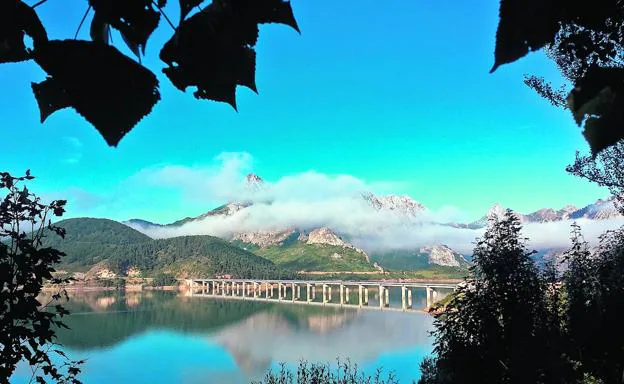 El viaducto cruza el pantano de Riaño, situado entre bosques y montañas rocosas.