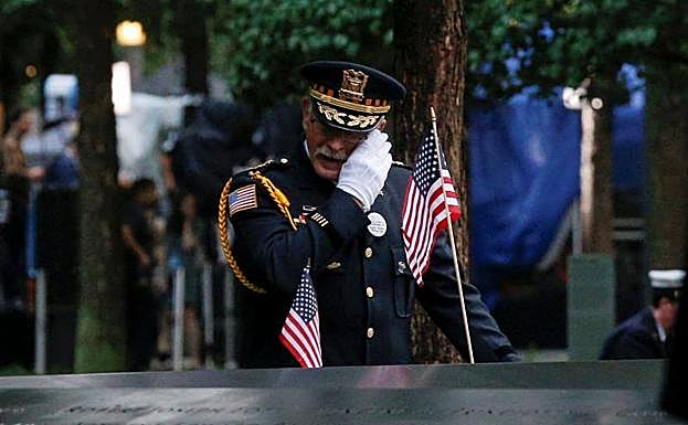 Un oficial de policía llora frente al monumento de recuerdo a las víctimas del 11-S en Nueva York.