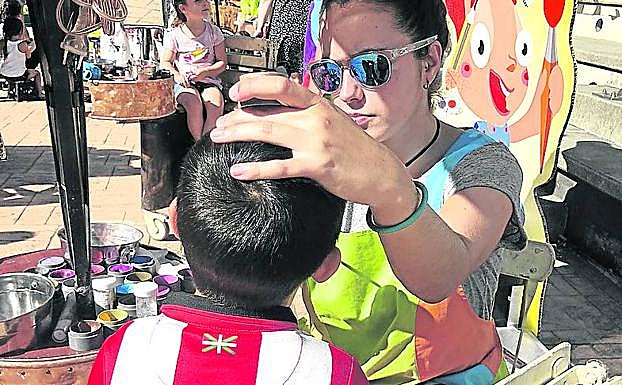 Una voluntaria dibuja en la cara de un niño. 