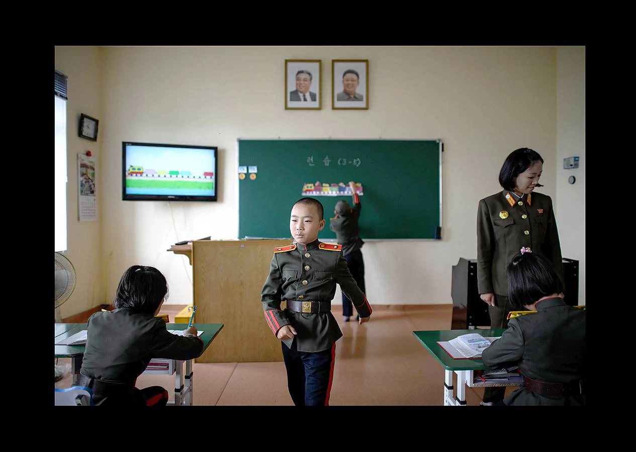 No muchas escuelas tienen aulas equipadas con tanques o simuladores de aviones de caza. La Escuela Revolucionaria Mangyongdae de Corea del Norte no es una institución ordinaria. Fue creada por el fundador del país, Kim Il Sung, para educar a los huérfanos de la guerra contra el gobierno colonial japonés y se ha convertido en un centro que une a la élite gobernante. Unos 1.000 niños con las cabezas rapadas, vestidos de uniforme militar con una línea roja en los pantalones que simboliza su devoción a la causa, ocupan sus clases. Son los escogidos, hijos e hijas de los patriotas que lucharon por el partido, el gobierno y el país; una élite cerrada y hereditaria.