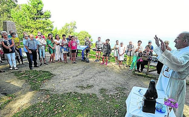 El sacerdote franciscano 'Aitxe' Adrian se dirige a los fieles durante la misa en plena costa.