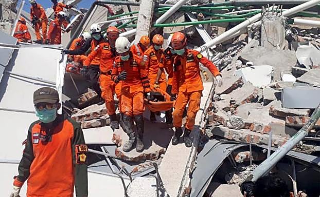 Los equipos de rescate retiran un cuerpo de los escombros.