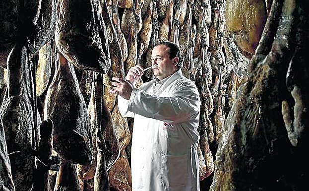 José Gómez comprueba la maduración de los jamones en una bodega.