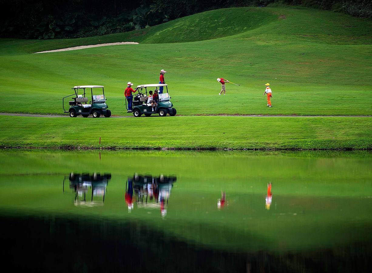 La Asociación China de Golf tenía 400 jugadores juveniles registrados en 2013, el año pasado eran 35.000 y se espera que en un lustro la cifra ronde los 100.000. Lai Runci, de 6 años, y Lai Yiyan, de 9 (protagonistas en la mayoría de las fotos), participan en un torneo para niños en Dragon Lake Golf Club en, Guangzhou. Ambos representan al ejército de jóvenes golfistas de China y el interés creciente del país por un juego que estuvo prohibido bajo el mandato de Mao Zedong porque era «para millonarios...»