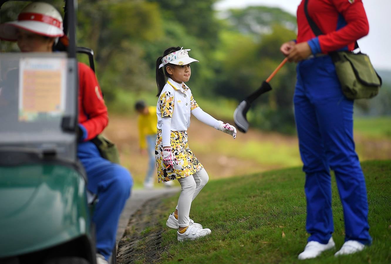 La Asociación China de Golf tenía 400 jugadores juveniles registrados en 2013, el año pasado eran 35.000 y se espera que en un lustro la cifra ronde los 100.000. Lai Runci, de 6 años, y Lai Yiyan, de 9 (protagonistas en la mayoría de las fotos), participan en un torneo para niños en Dragon Lake Golf Club en, Guangzhou. Ambos representan al ejército de jóvenes golfistas de China y el interés creciente del país por un juego que estuvo prohibido bajo el mandato de Mao Zedong porque era «para millonarios...»