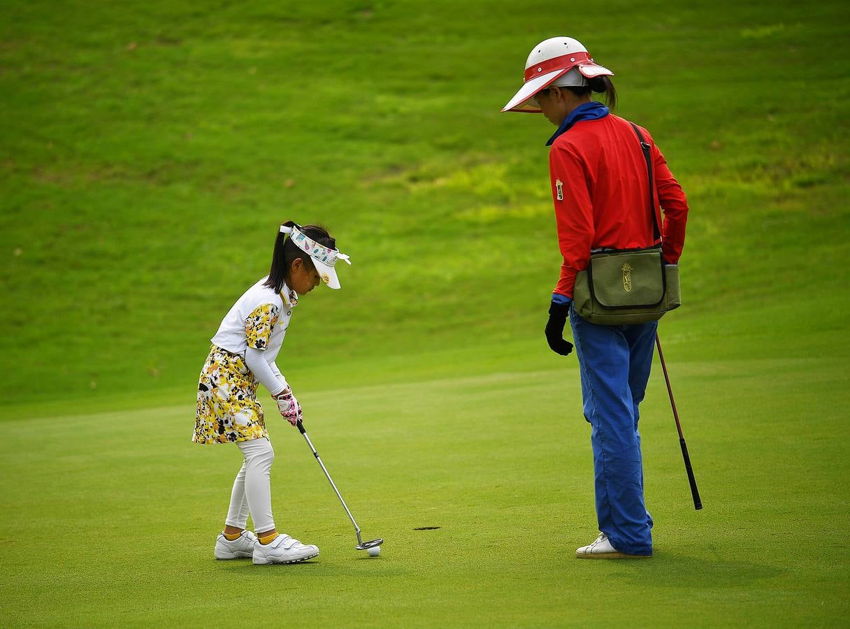 La Asociación China de Golf tenía 400 jugadores juveniles registrados en 2013, el año pasado eran 35.000 y se espera que en un lustro la cifra ronde los 100.000. Lai Runci, de 6 años, y Lai Yiyan, de 9 (protagonistas en la mayoría de las fotos), participan en un torneo para niños en Dragon Lake Golf Club en, Guangzhou. Ambos representan al ejército de jóvenes golfistas de China y el interés creciente del país por un juego que estuvo prohibido bajo el mandato de Mao Zedong porque era «para millonarios...»