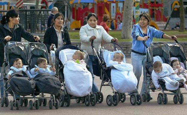 Varias mujeres latinoamericanas cuidan niños en un parque. 