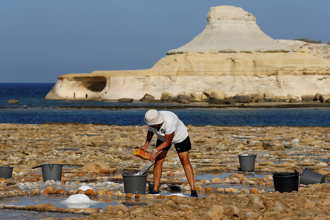 Zebbug, en la isla de Gozo, en Malta, es una pequeña localidad famosa por sus finos encajes; por los olivos, que le dieron el nombre, y por la sal. A ella se dedican numerosos habitantes que, como Josephine Xuereb y Rosa Cini (en las fotos), la tratan y almacenan en salinas excavadas en roca y en paneles de evaporación, que se extienden a lo largo de la costa, de la misma forma que hicieron otras generaciones desde hace más de 350 años. 