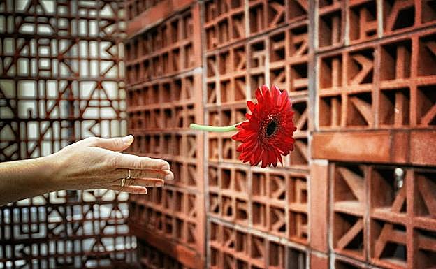 Un flor es depositada en una ofrenda en homenaje a las victimas del terrorismo, junto a la escultura , Brujula de Medianoche.