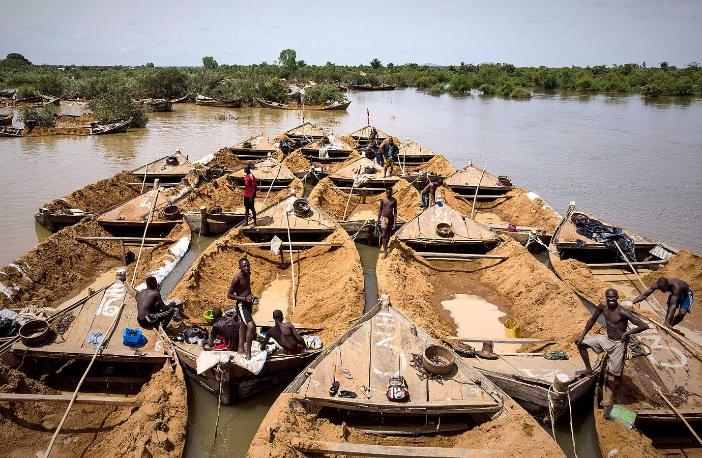 El auge de la construcción en Bamako, la capital de Mali, ha generado un espectacular aumento de la demanda de ladrillos fabricados con arena de alta calidad excavada a mano desde el lecho del río Níger. A esta ardua y peligrosa actividad se dedican decenas de personas, que acuden al lugar de extracción desde cientos de kilómetros y arriesgan sus vidas por alrededor de seis euros al día. Las corrientes y tormentas ponen muy a menudo en peligro sus frágiles embarcaciones