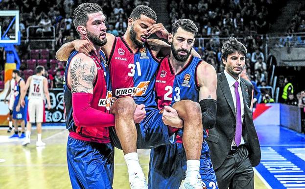 Vincent Poirier y Tornike Shengelia levantan en vilo a Shavon Shields, conmocionado tras el codazo que recibió Axel Toupane.