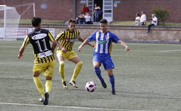 Amorrortu trata de avanzar con el balón ante dos jugadores del Barakaldo. 