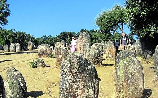 Dos visitantes recorren el conjunto megalótico de Almendres. 