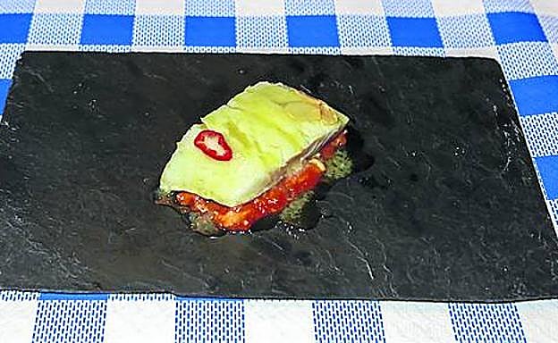 La tajada de bacalao sobre manitas de cordero.