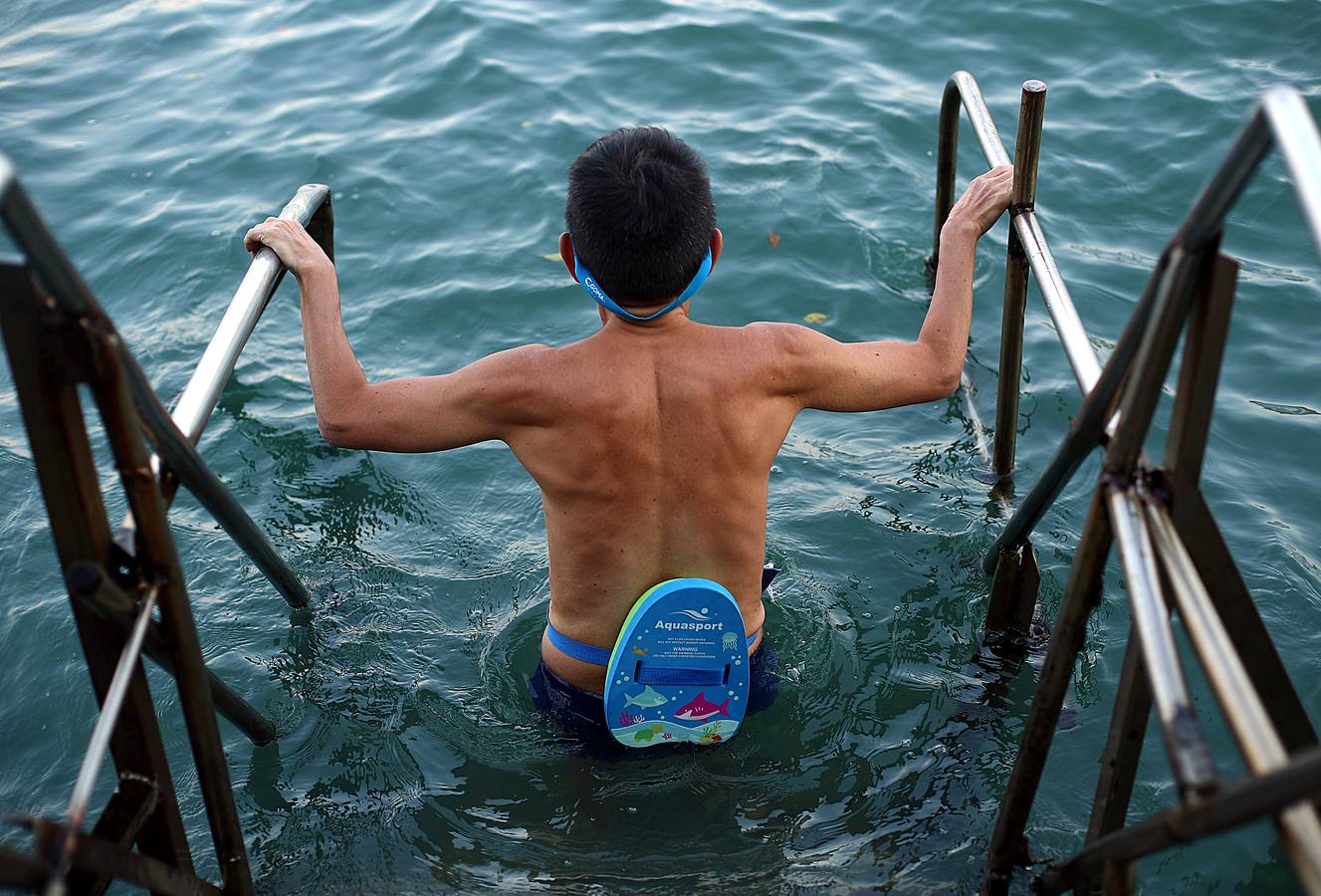 A Sandy Lam, de 68 años, le gusta zambullirse en las aguas del puerto de Hong Kong. Él (con una toalla blanca) y la mayor parte de los veteranos personajes que aparecen en las fotos llevan haciéndolo durante décadas frente al corazón financiero de la isla, rodeados de contenedores, ferris y barcos de pesca. A todos les une el deseo de mantenerse en forma. Su única queja es la contaminación: «Noto que hay más plástico en el mar. Es muy distinto a cuando nadaba aquí de pequeño. En el futuro será un problema.»