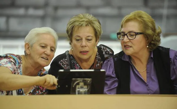 Tres mujeres manejan un iPad durante la pasada edición. 