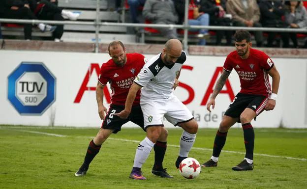 Pradera protege la pelota ante dos jugadores rojillos. 