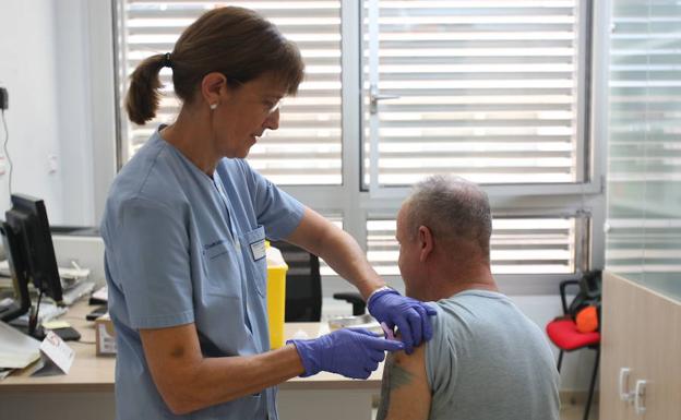 Un hombre recibe la vacuna contra la gripe.