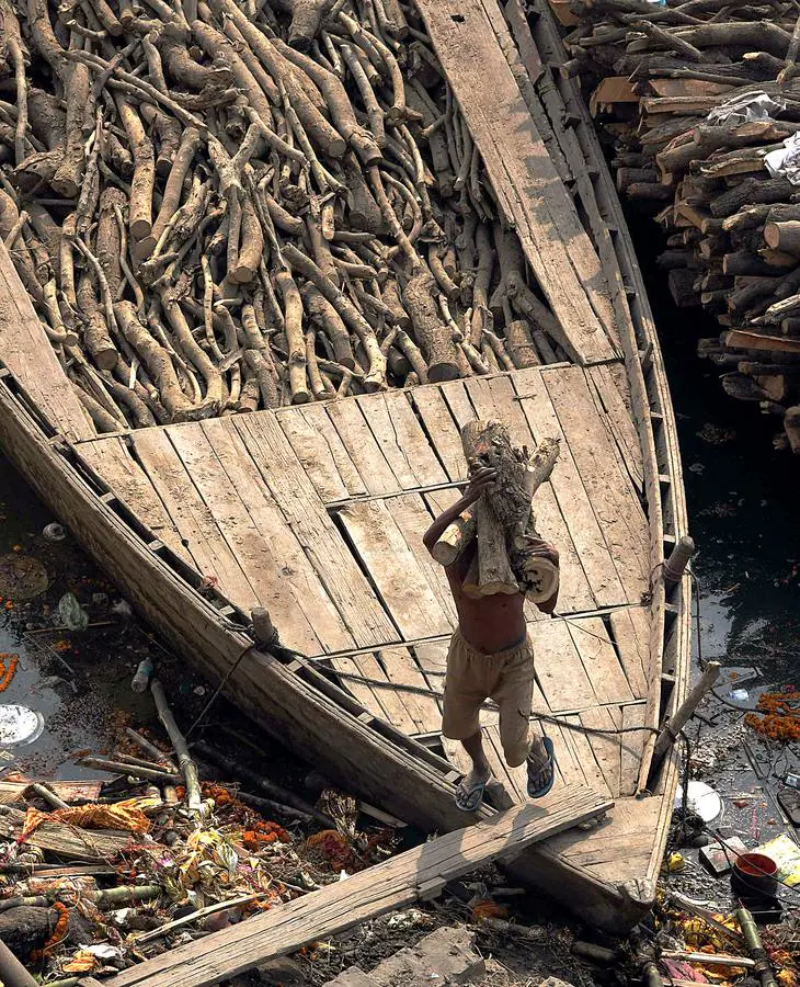 Todo hindú desea ser incinerado en Varanasi, la ciudad sagrada en el norte de la India. En sus ghats, a orillas del Ganges (en las fotografías vemos el ghat de Manikarnika), las piras funerarias son constantes y numerosos barcos cargados de madera la depositan con frecuencia. Cada una de las alrededor de 200 cremaciones que se realizan a diario necesita entre 200 y 400 kilos de madera, lo que significa que son consumidas hasta 80 toneladas. Un problema más para la polución en el país.