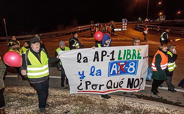 Miembros de la Plataforma de la AP-1 durante la ofrenda floral organizada anoche en Briviesca a los fallecidos en la N-1 entre Burgos y Miranda de Ebro. 