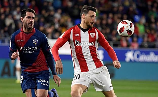Aduriz lucha por un balón con un jugador del Huesca.