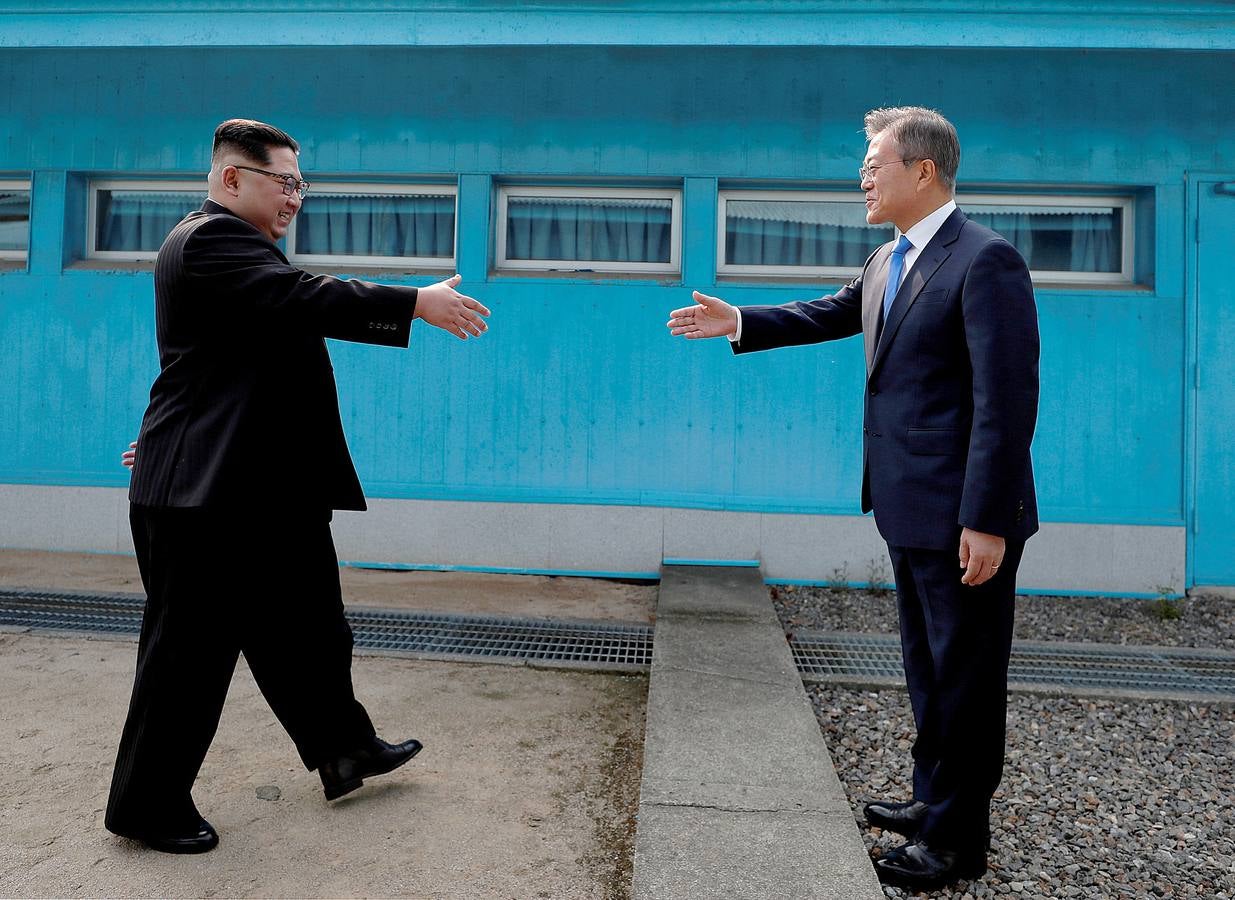 El presidente de Corea del Sur, Moon Jae-in, y el líder de Corea del Norte, Kim Jong Un, se dan la mano en el pueblo de la tregua de Panmunjom dentro de la zona desmilitarizada que separa a las dos Coreas.