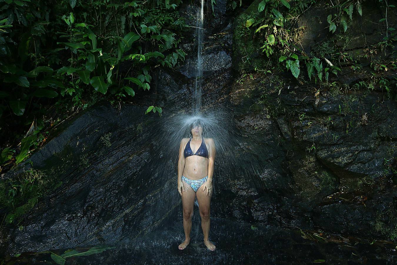 Hoy comienza el verano austral. Pero las playas de Río de Janeiro ya están llenas de bañistas desde hace unas semanas. Y es que el calor aprieta. El martes los termómetros alcanzaron 40,7 grados en la zona oeste de la ciudad, en el que ha sido el día más caluroso en varios años, con una sensación térmica de 45 grados. El mar está calmado y apenas hay olas en las transparentes aguas. Las imágenes han sido tomadas en la Floresta de Tijuca, el bosque urbano más grande del mundo, y en los arenales del oeste de Río.