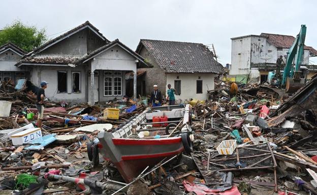 Los aldeanos caminan entre los escombros del tsunami en el pueblo de Sumber Jaya en Sumur, Pandeglang.