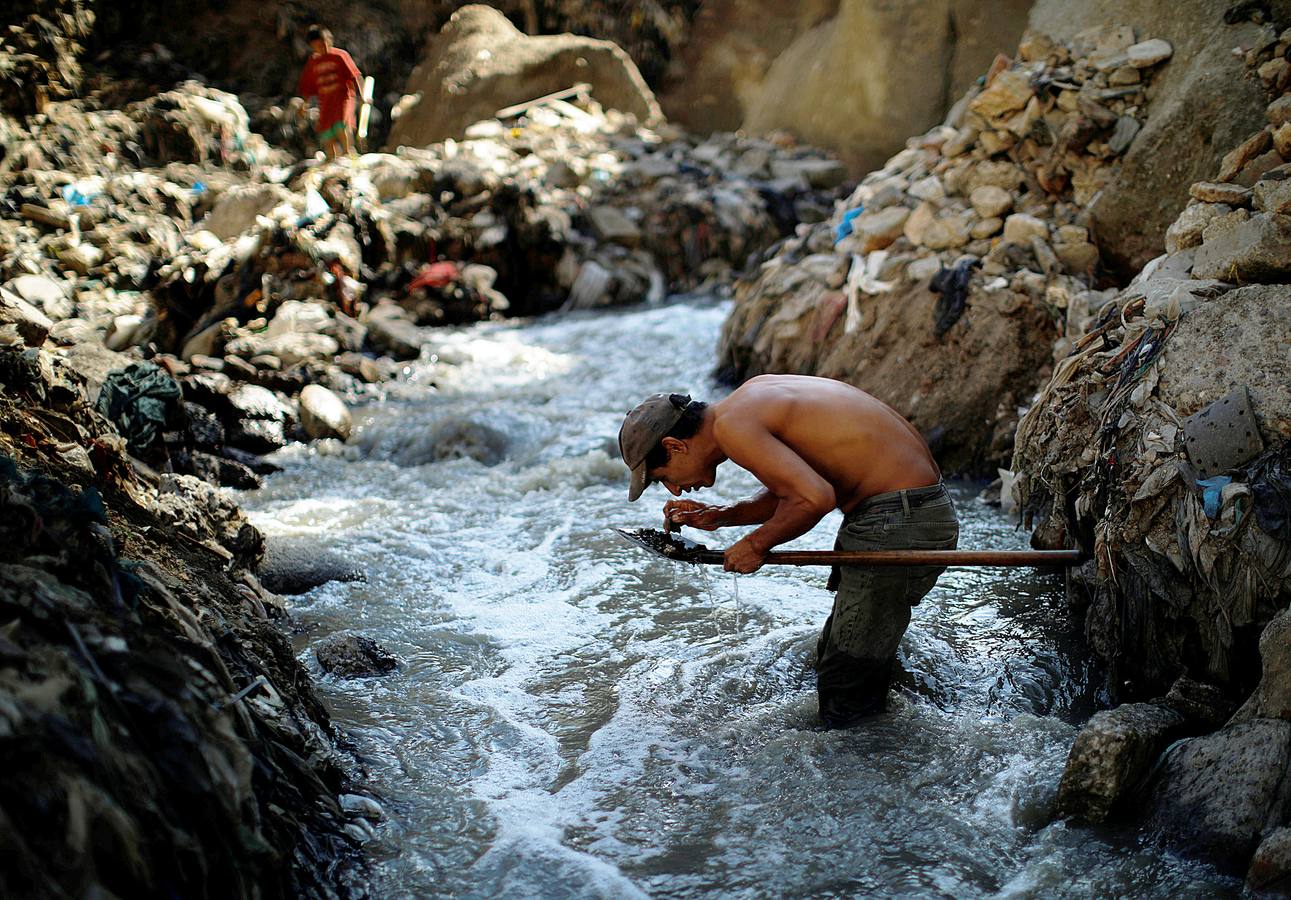 'La Mina', en la ciudad de Guatemala, se encuentra al fondo de un barranco atravesado por un río. Centenares de personas se afanan cada día entre sus aguas contaminadas, bajo la amenaza de deslizamientos y enfermedades, para tratar de encontrar objetos o chatarra con la que ganarse la vida. Algunos utilizan imanes para atraparlos, otros lo hacen a mano, introduciendo su cuerpo directamente en el agua, convertida en basurero. Si hay suerte pueden conseguir unos 20 dólares, el doble del salario mínimo. En ocasiones hasta es posible hallar un anillo o un pendiente de oro.
