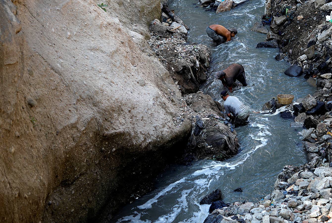'La Mina', en la ciudad de Guatemala, se encuentra al fondo de un barranco atravesado por un río. Centenares de personas se afanan cada día entre sus aguas contaminadas, bajo la amenaza de deslizamientos y enfermedades, para tratar de encontrar objetos o chatarra con la que ganarse la vida. Algunos utilizan imanes para atraparlos, otros lo hacen a mano, introduciendo su cuerpo directamente en el agua, convertida en basurero. Si hay suerte pueden conseguir unos 20 dólares, el doble del salario mínimo. En ocasiones hasta es posible hallar un anillo o un pendiente de oro.