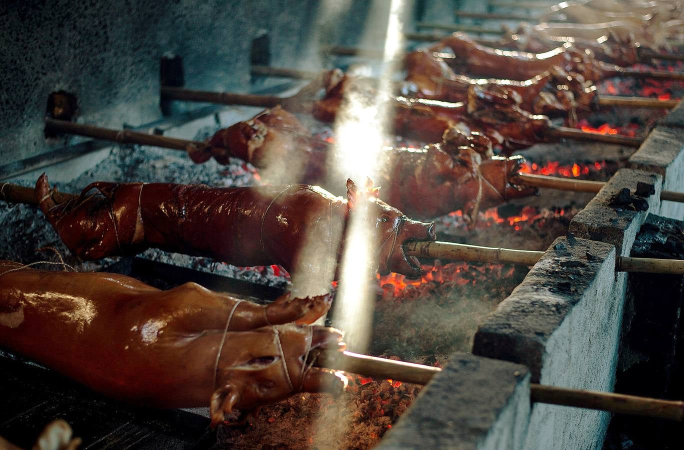 El territorio filipino está compuesto por más de 7.000 islas en las que se distribuyen los 100 millones de habitantes del país. Su complicada interconexión insular ha facilitado la aparición en el tiempo de una enorme variedad de lenguas y comidas locales. Una de ellas es el lechón relleno con papaya y hojas de tamarindo, que se pone a la brasa y se sirve con arroz acompañado con salsa de hígado. Los lechoneros (los vemos en las fotos) se dedican a girar el asado durante horas y lo bañan de tanto en tanto con agua de coco.