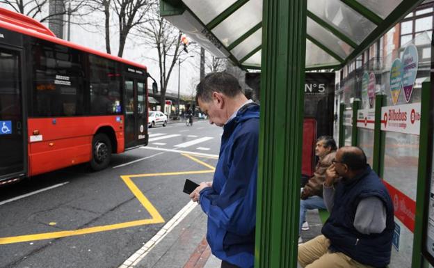 Varios usuarios esperan en la parada de Gran Vía.