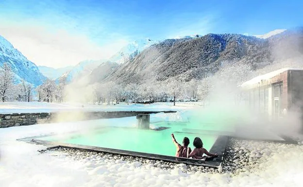 Una pareja observa el paisaje desde la piscina exterior de aguas cálidas de Balnéa, en Loudenvielle (Val Louron).